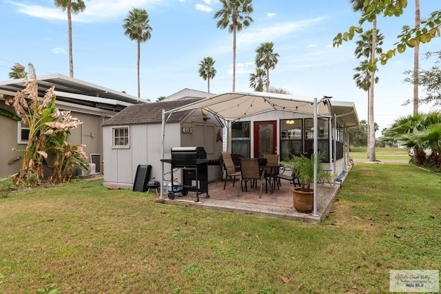 rear view of house with a yard, an outdoor structure, and a patio