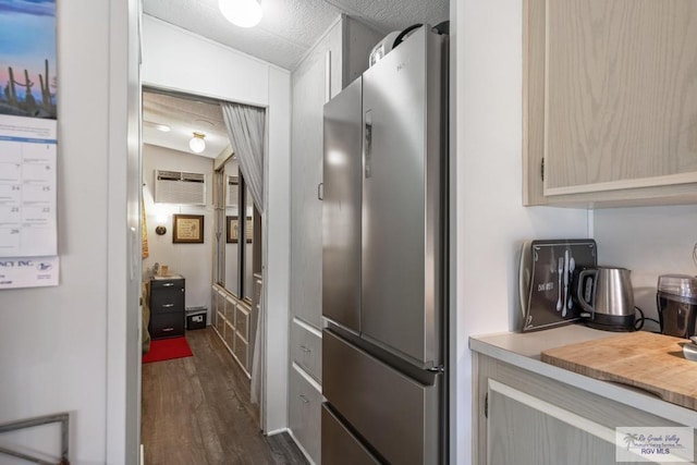 kitchen featuring dark wood-style floors, a wall mounted air conditioner, freestanding refrigerator, light countertops, and a textured ceiling