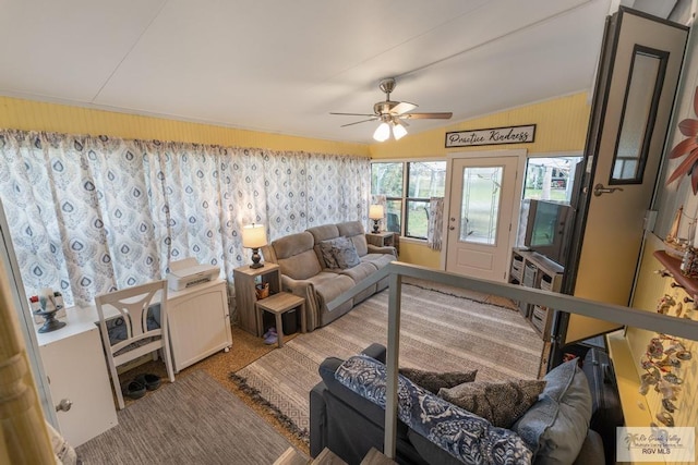 living area with vaulted ceiling, carpet flooring, and a ceiling fan