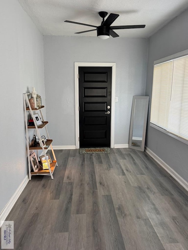 entrance foyer featuring a ceiling fan, a textured ceiling, baseboards, and wood finished floors