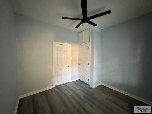 unfurnished bedroom with dark wood-type flooring, baseboards, and a ceiling fan