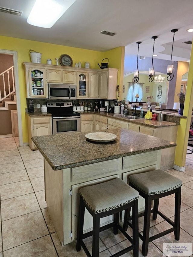 kitchen with a breakfast bar, a kitchen island, sink, and stainless steel appliances