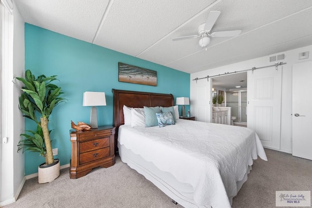 3000 Gulf Blvd, South Padre Island, TX 78597 - carpeted bedroom with ensuite bath, a ceiling fan, and a textured ceiling
