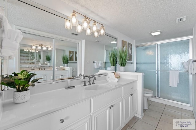 3000 Gulf Blvd, South Padre Island, TX 78597 - bathroom featuring a chandelier, tile patterned flooring, vanity, a stall shower, and a textured ceiling
