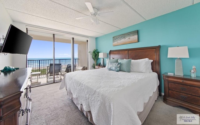 3000 Gulf Blvd, South Padre Island, TX 78597 - carpeted bedroom featuring access to exterior, a textured ceiling, a ceiling fan, and a wall of windows