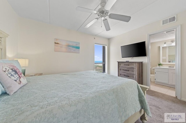 3000 Gulf Blvd, South Padre Island, TX 78597 - bedroom with light colored carpet, ceiling fan, light tile patterned flooring, and connected bathroom