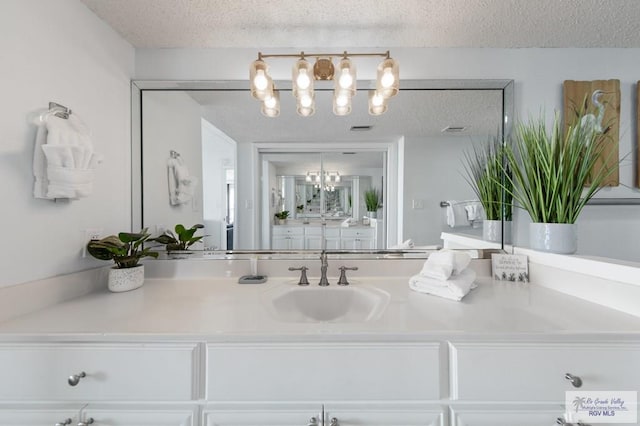 3000 Gulf Blvd, South Padre Island, TX 78597 - bathroom with a chandelier, a textured ceiling, and vanity