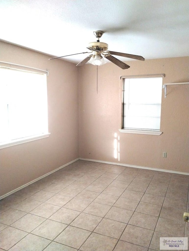 tiled spare room with ceiling fan