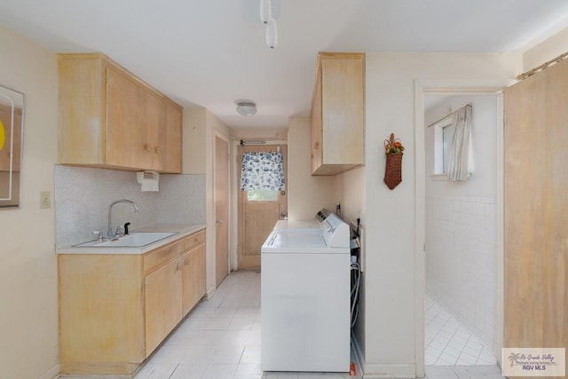 washroom with washer and clothes dryer, cabinets, light tile patterned floors, and sink