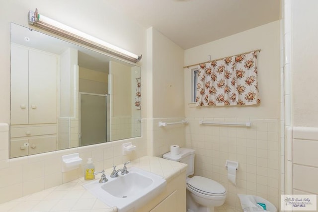 bathroom featuring an enclosed shower, vanity, toilet, and tile walls