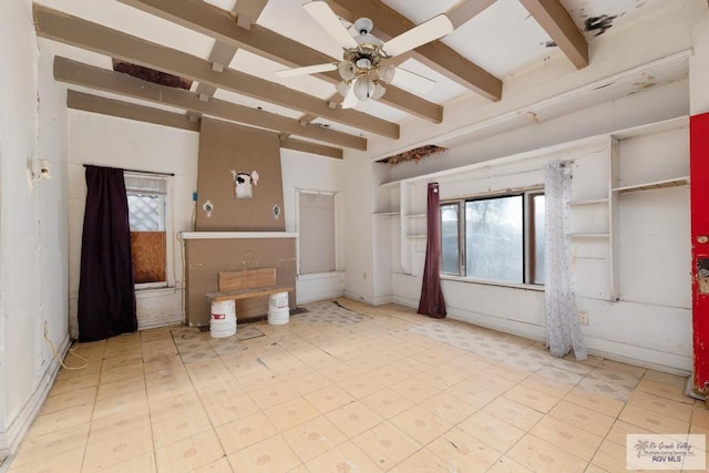 unfurnished living room with beam ceiling and ceiling fan