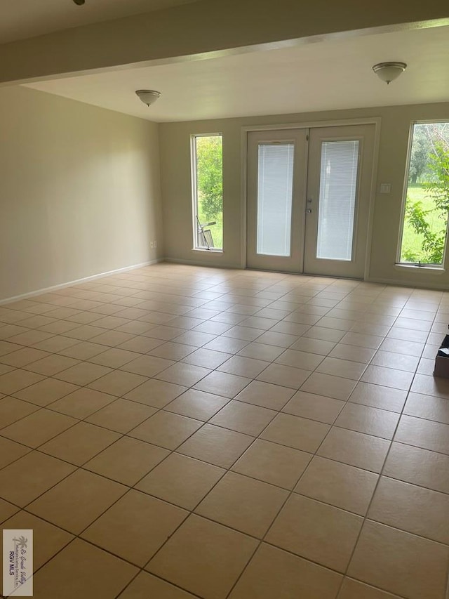 unfurnished room with light tile patterned flooring and french doors