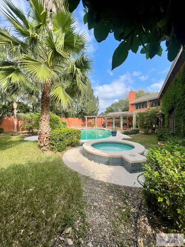 view of pool featuring a pergola, an in ground hot tub, and a lawn