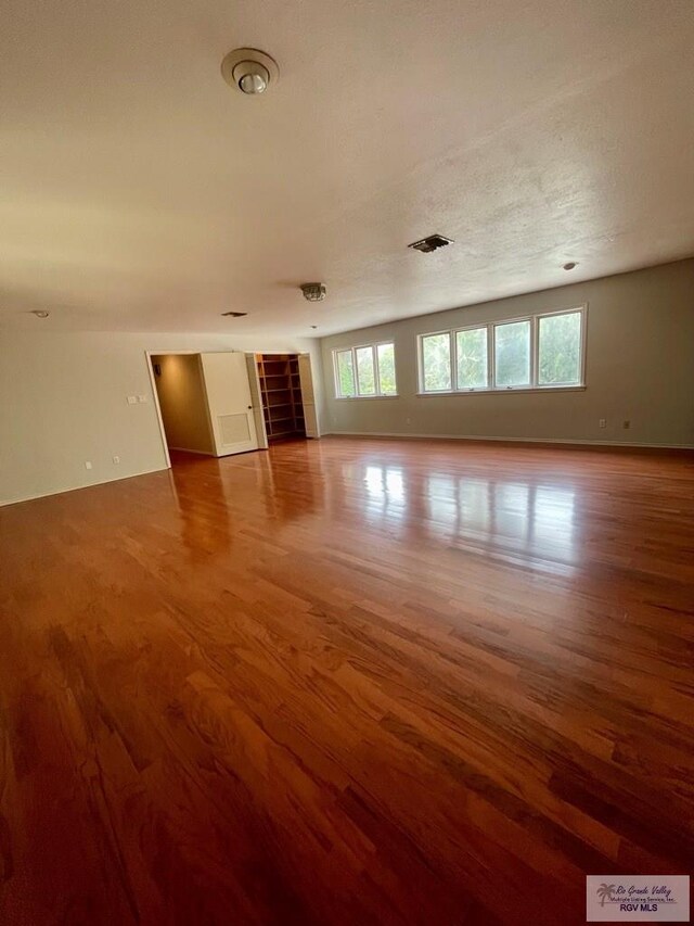 spare room featuring wood-type flooring and a textured ceiling