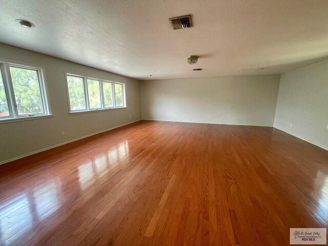 unfurnished room featuring hardwood / wood-style floors and a textured ceiling