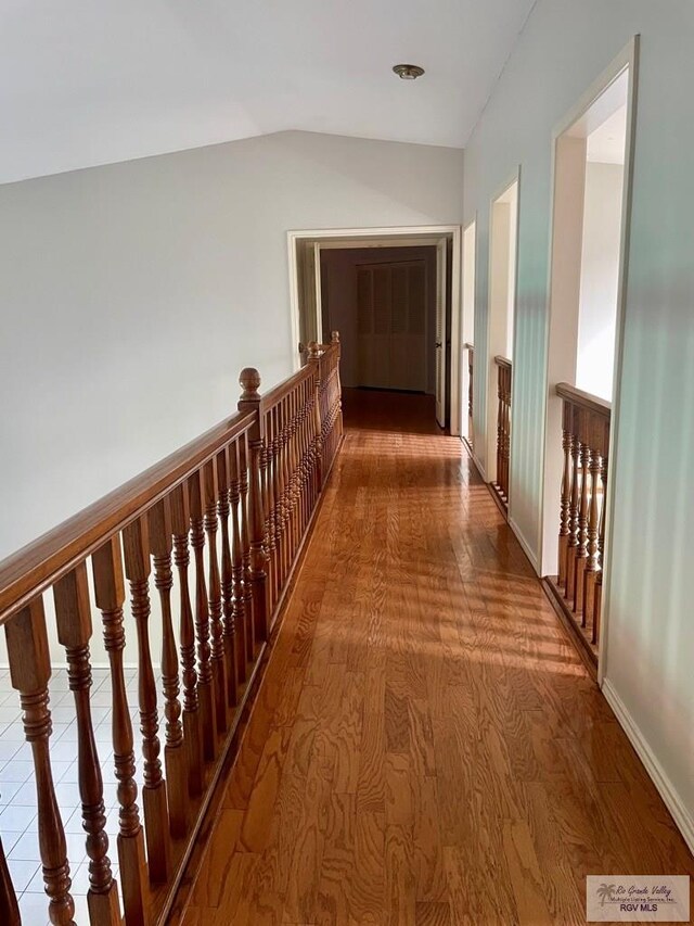 hallway featuring hardwood / wood-style flooring and lofted ceiling