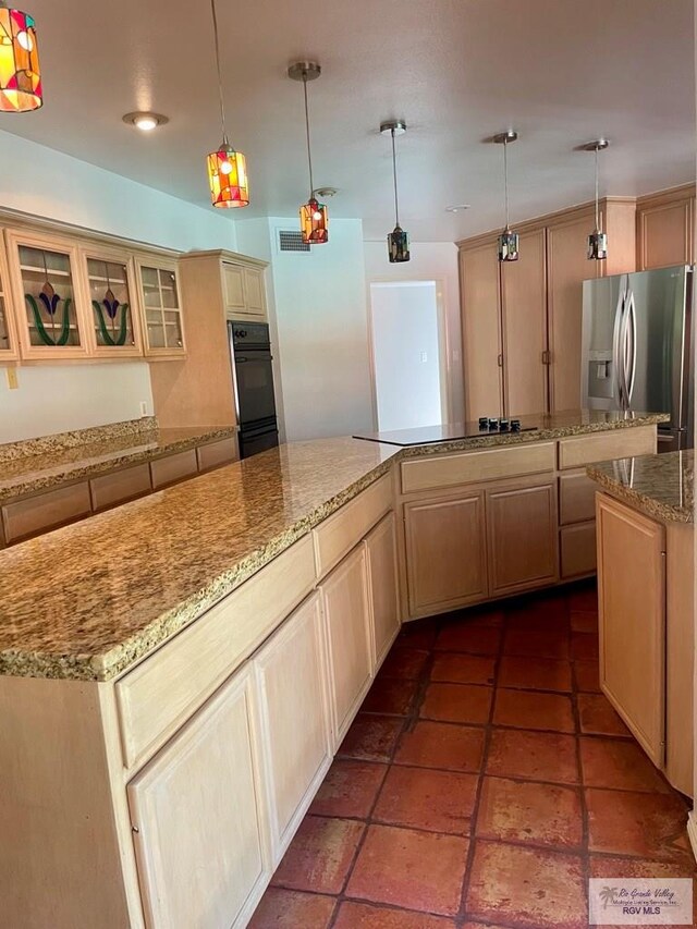 kitchen with pendant lighting, light brown cabinetry, a center island, and black appliances