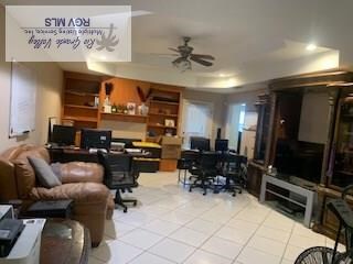 tiled office space featuring ceiling fan and a raised ceiling