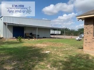 view of yard with an outbuilding, a detached garage, and an outdoor structure