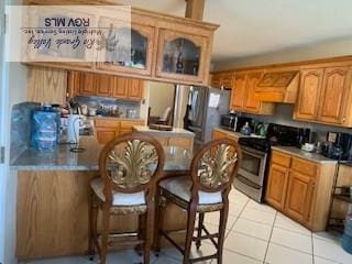 kitchen featuring light tile patterned floors, custom range hood, and appliances with stainless steel finishes