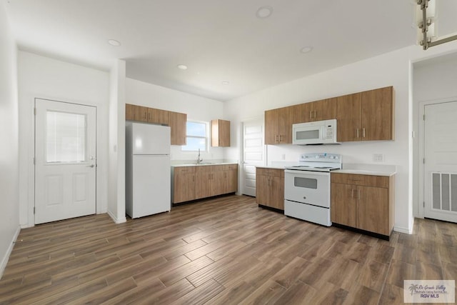 kitchen featuring white appliances, dark hardwood / wood-style floors, and sink