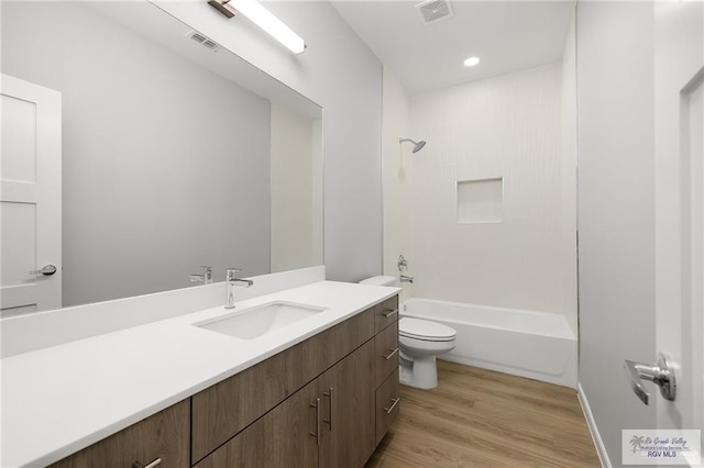 full bathroom with hardwood / wood-style floors, vanity, toilet, and  shower combination