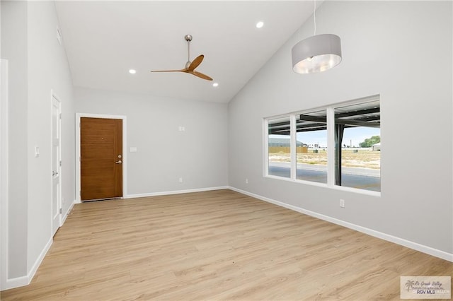 spare room featuring ceiling fan, light wood-type flooring, and high vaulted ceiling