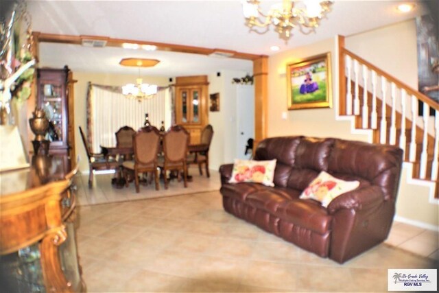 living area featuring tile patterned floors, visible vents, an inviting chandelier, and stairs