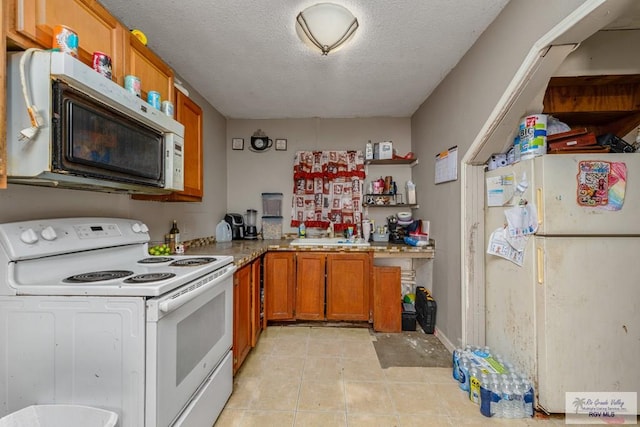 kitchen featuring white appliances, a textured ceiling, open shelves, a sink, and brown cabinets
