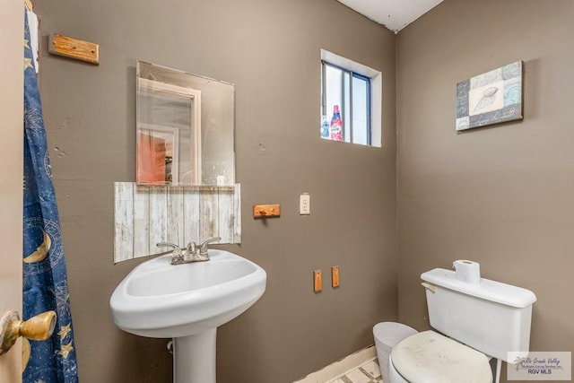 bathroom with baseboards and toilet