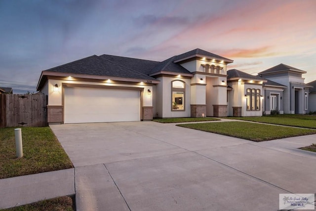 prairie-style house featuring a garage and a lawn