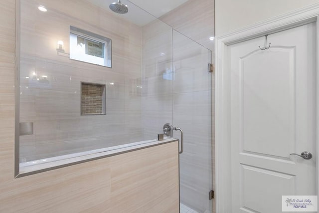 bathroom featuring a shower with door