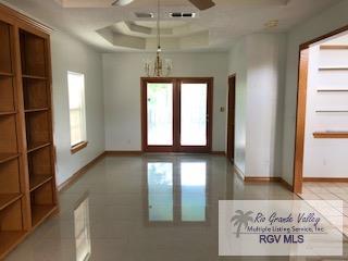 spare room with a tray ceiling, a wealth of natural light, and ceiling fan