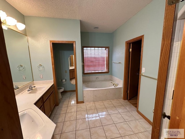 bathroom with tile patterned flooring, vanity, a textured ceiling, and toilet