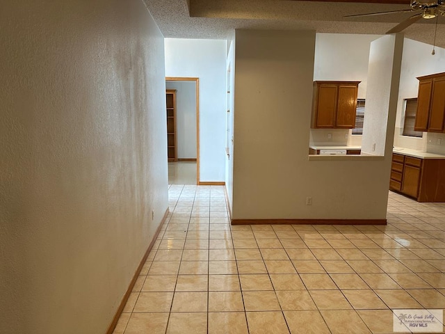 kitchen featuring ceiling fan, light tile patterned floors, and a textured ceiling