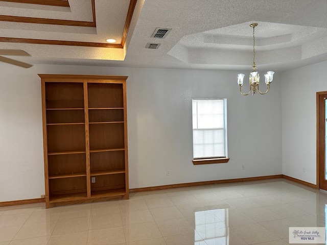 spare room featuring a raised ceiling, light tile patterned flooring, a textured ceiling, and a notable chandelier