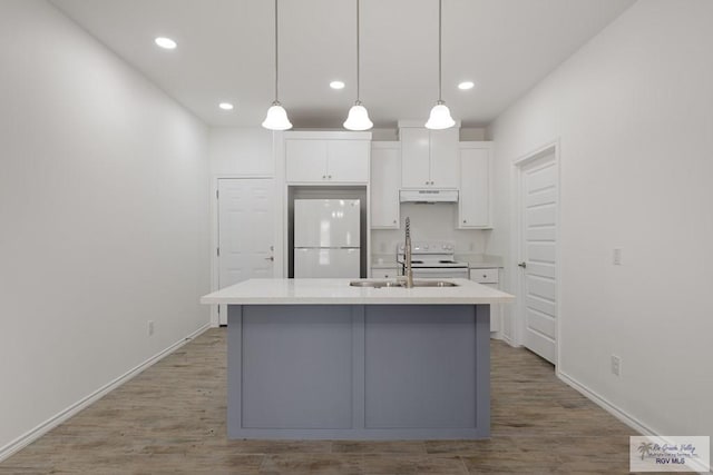 kitchen with white cabinetry, sink, decorative light fixtures, white appliances, and a kitchen island with sink