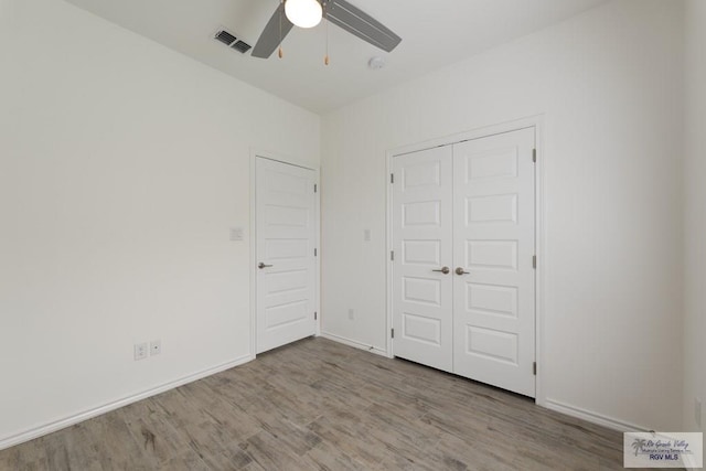 unfurnished bedroom with ceiling fan, light hardwood / wood-style floors, and a closet