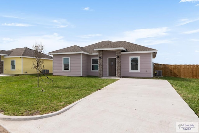 view of front of property with central AC and a front lawn