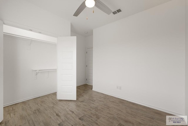 unfurnished bedroom with hardwood / wood-style floors, a closet, and ceiling fan