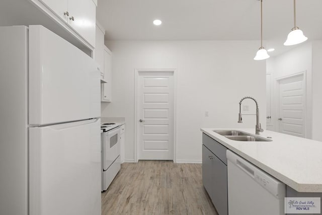 kitchen with white appliances, sink, a center island with sink, white cabinets, and hanging light fixtures