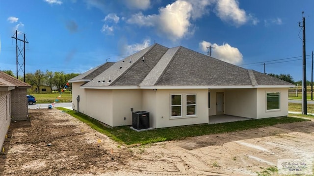 rear view of house with central AC unit and a patio area