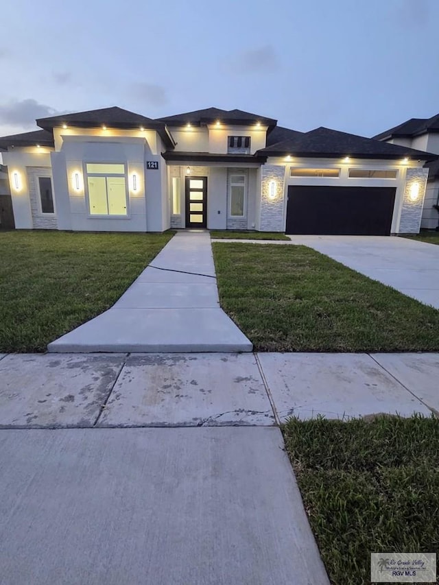 121 Finch Dr, Los Fresnos, TX 78566 - prairie-style house featuring a front yard, an attached garage, driveway, and stucco siding