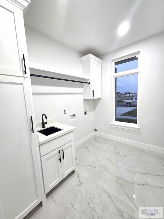 121 Finch Dr, Los Fresnos, TX 78566 - laundry area featuring electric dryer hookup, light marble finish floors, cabinet space, and washer hookup