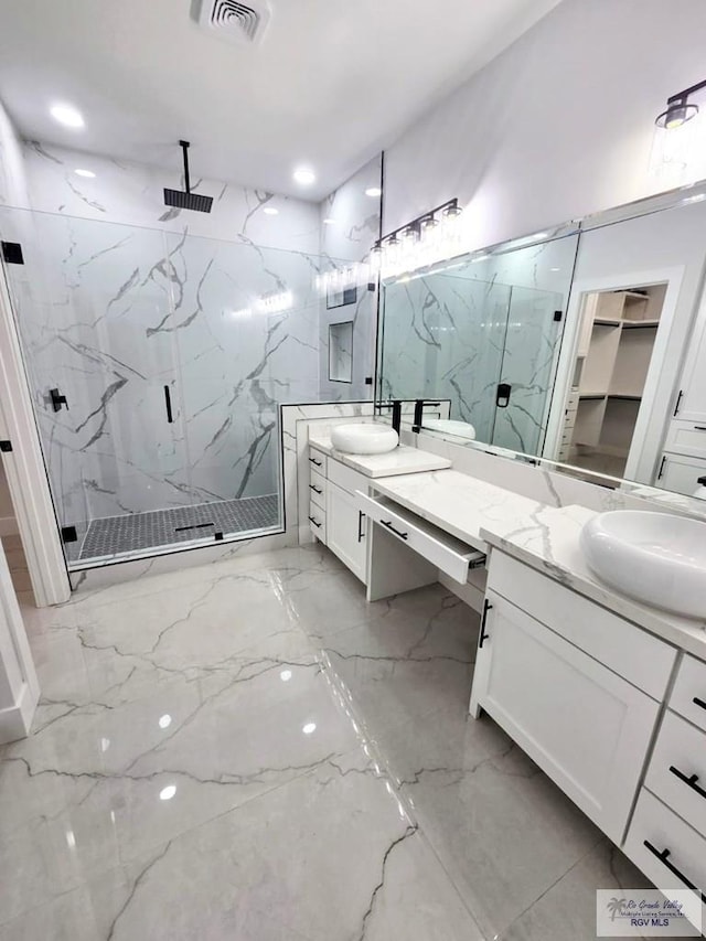 121 Finch Dr, Los Fresnos, TX 78566 - bathroom with a marble finish shower, marble tiled flooring, vanity, and a spacious closet