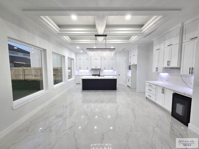 121 Finch Dr, Los Fresnos, TX 78566 - kitchen featuring light marble finish flooring, white cabinetry, recessed lighting, a kitchen island, and decorative backsplash