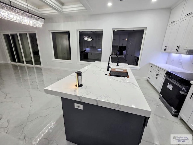 121 Finch Dr, Los Fresnos, TX 78566 - kitchen with range, light marble finish floors, light stone counters, white cabinets, and a kitchen island with sink