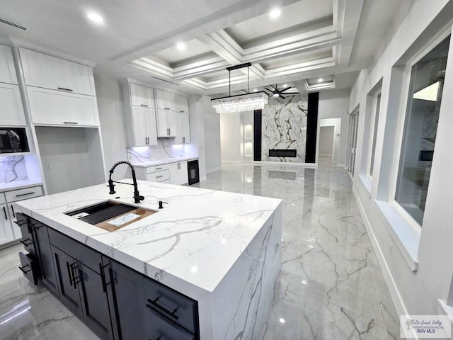 121 Finch Dr, Los Fresnos, TX 78566 - kitchen featuring light marble finish flooring, white cabinets, open floor plan, ceiling fan, and coffered ceiling