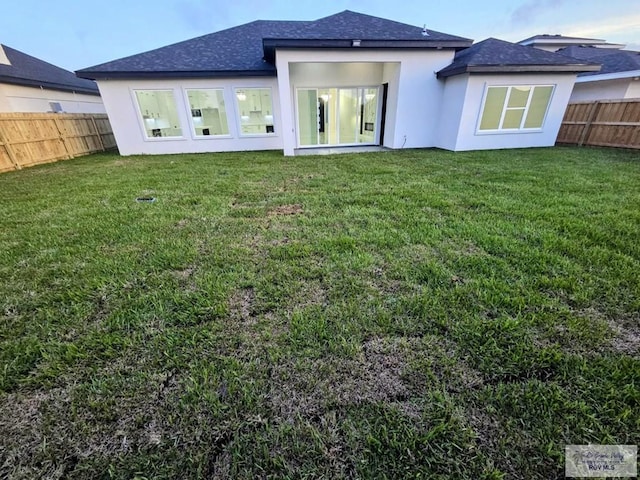 121 Finch Dr, Los Fresnos, TX 78566 - back of house with a fenced backyard, stucco siding, and a shingled roof