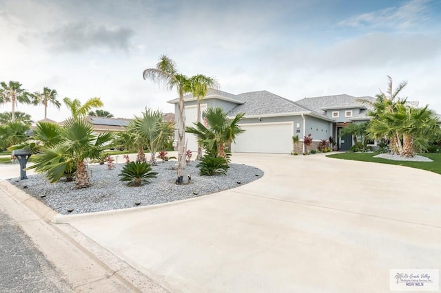38 Spoonbill Cove Rd, Laguna Vista, TX 78578 - view of front of house with curved driveway, a garage, and stucco siding